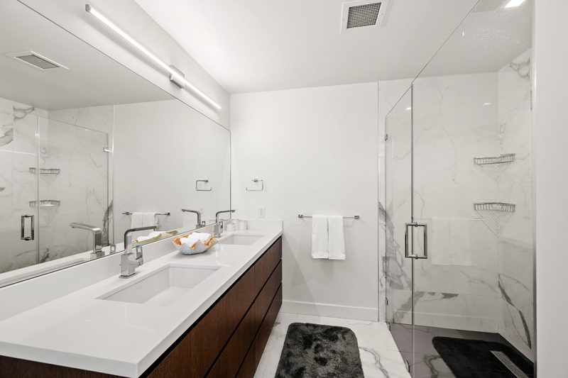Dual sink vanity and room walk-in shower in the primary bathroom.