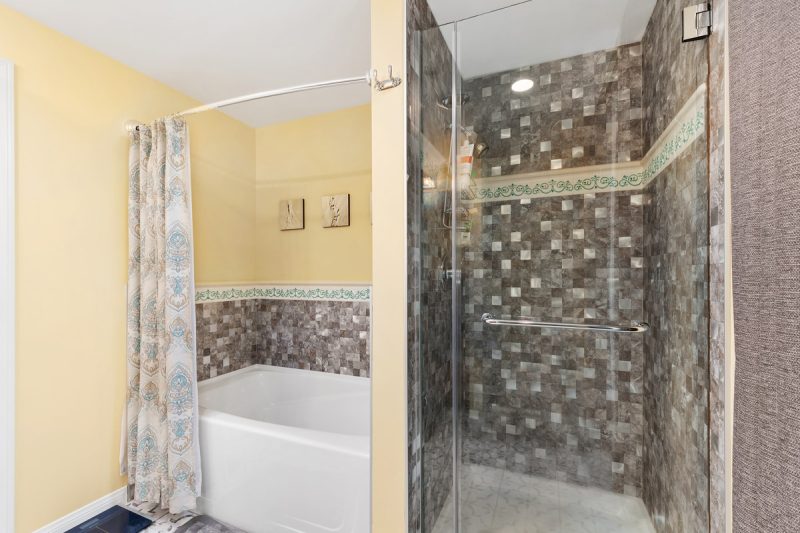 Spacious walk-in shower and separate bathtub in the primary bathroom.