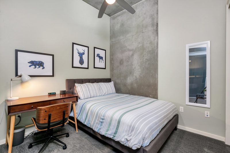 Guest bedroom with a queen size bed and convenient desk.