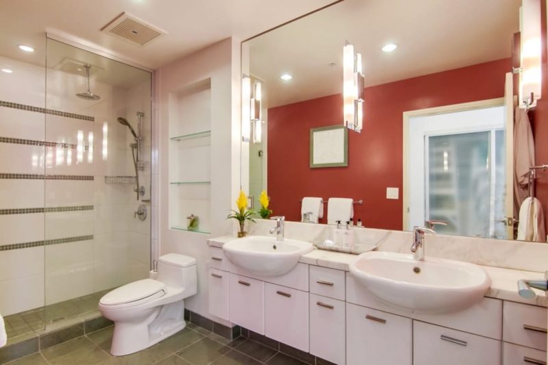 Spacious master bathroom with a red accent wall.